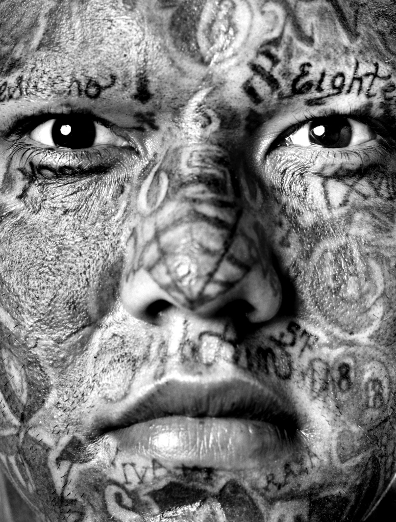Photography of a tattooed gang member by Isabel Munoz.