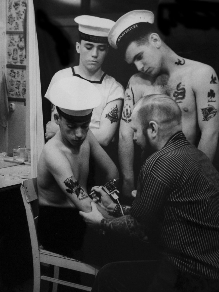 Sailors at a tattoo shop.