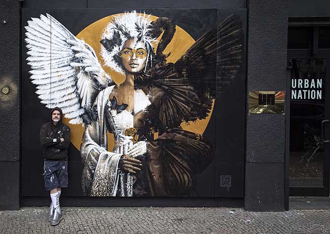 Findac with his mural outside Project M, Urban Nation