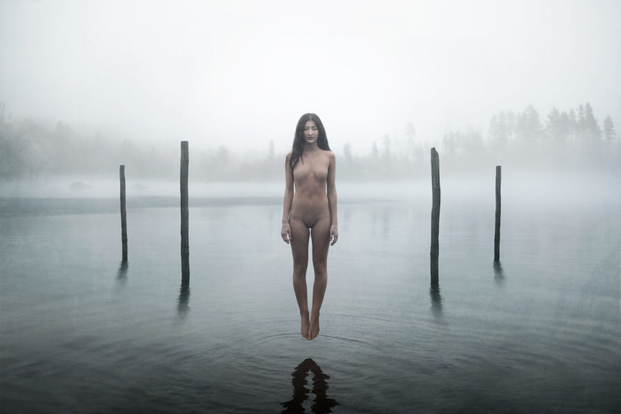 Floating nude woman above water