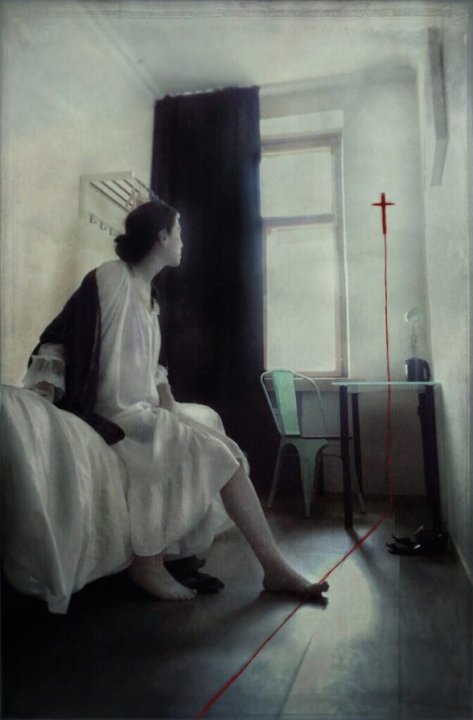 Ana Priscila Rodriguez photograph of woman sitting on the edge of a bed in a small room and looking at window